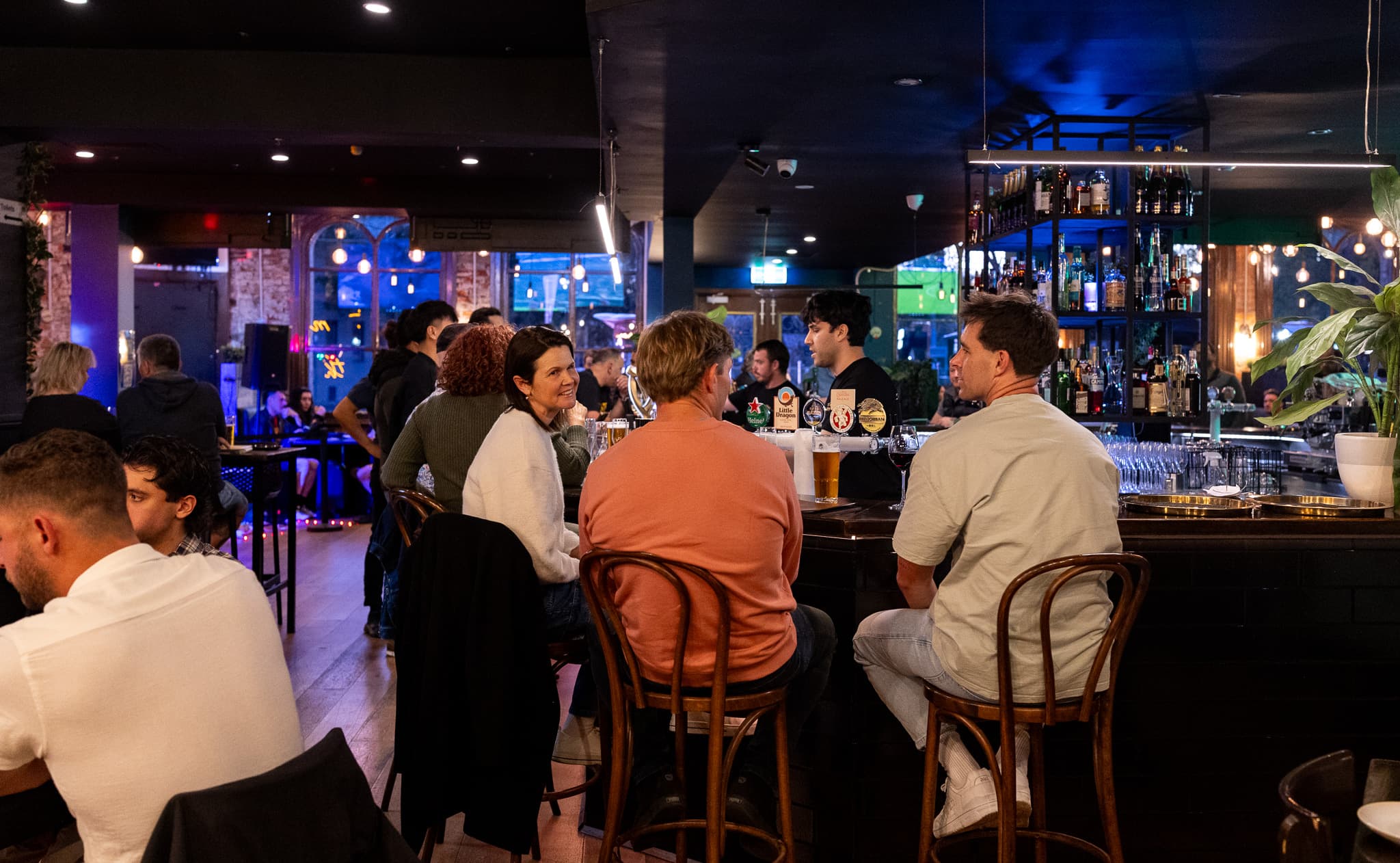 Guests gathering around the bar at The Cornerstone Pub